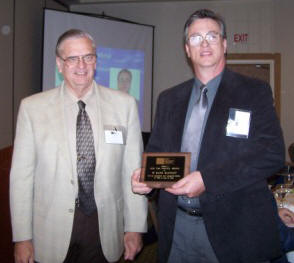 Mark McGinley (right) accepts congratulations from John Chrysler (left) upon receiving a 2008 TMS Service Award.