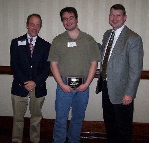 Jason Thompson (center) accepts congratulations upon receiving a 2006 TMS Service Award for his exceptional service as Secretary of the Masonry Standards Joint Committee (MSJC).